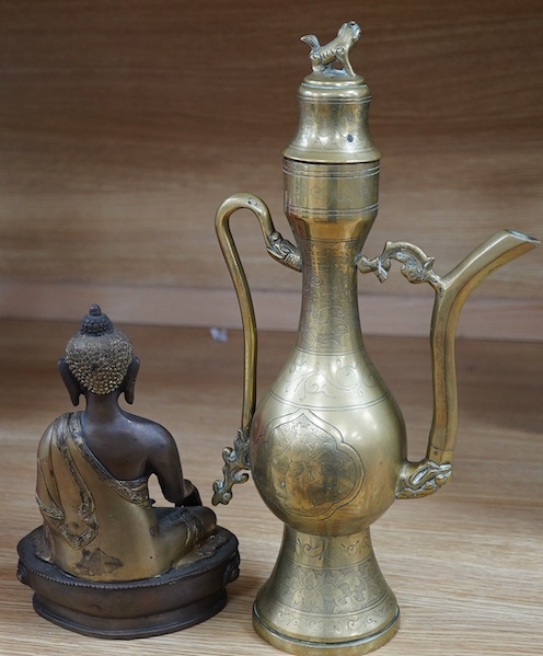 A South East Asian bronze Buddha and an engraved brass wine ewer, 39cm high. Condition - good